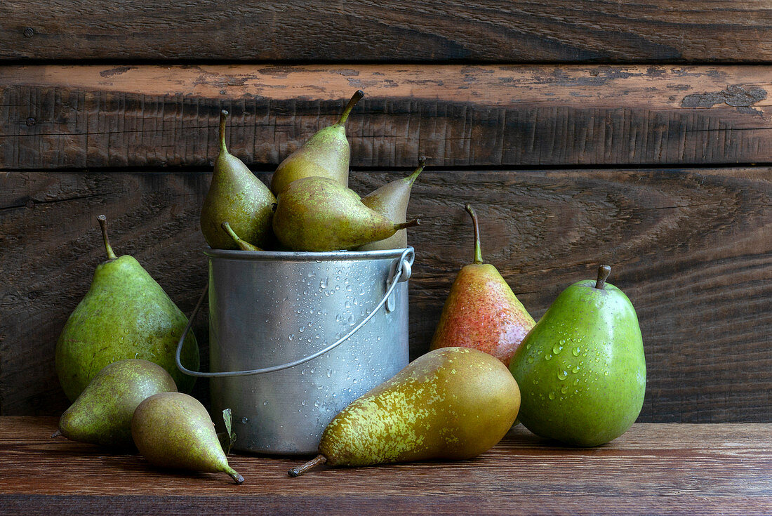 A composition of different kinds of pears on a wooden table in the garden