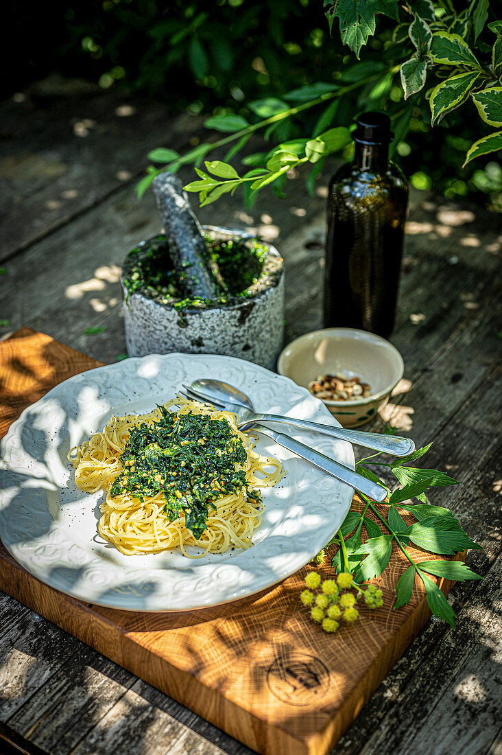 Spaghetti mit Liebstöckel-Pesto auf Tisch im Freien