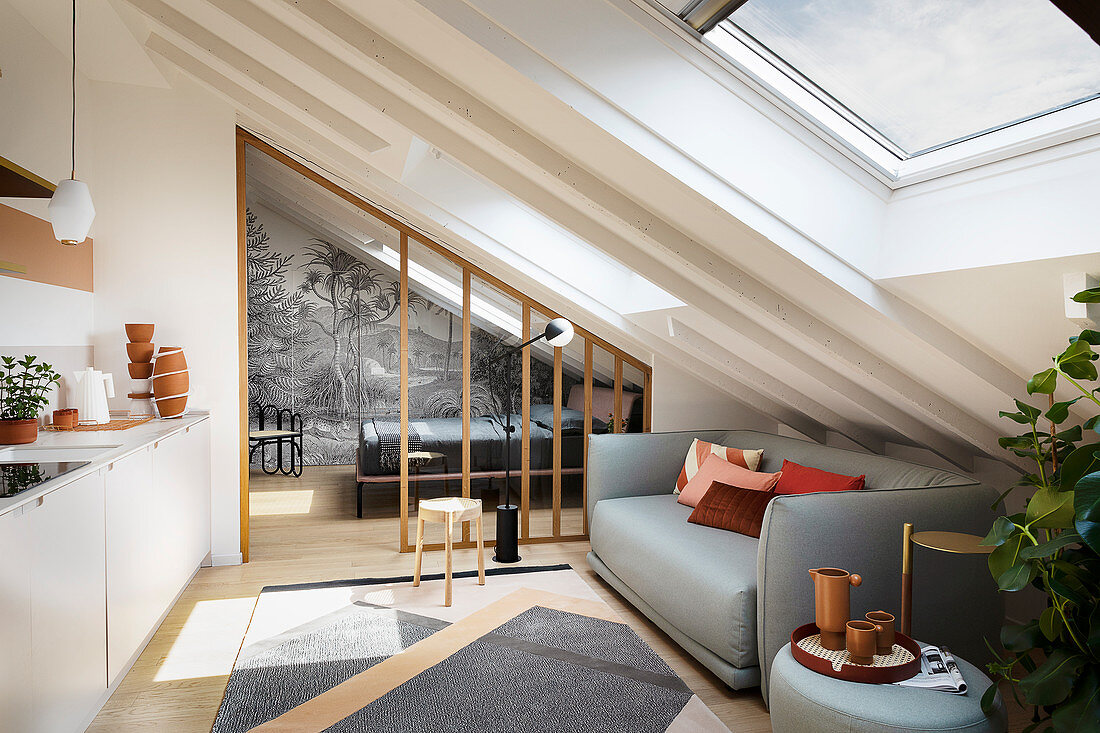 A light grey sofa in a modern kitchen in an attic room