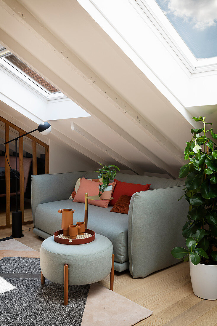 A light grey sofa and a matching coffee table in an attic room