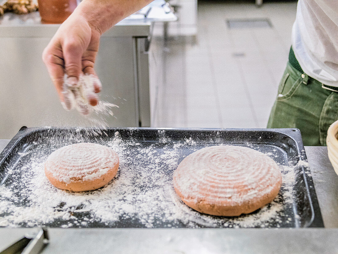 Dusting loaves of bread with flour