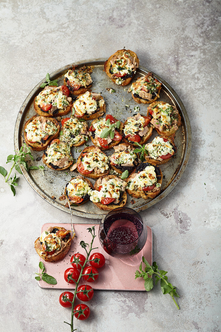 Baked bruschetta with olives, tuna and cherry tomatoes