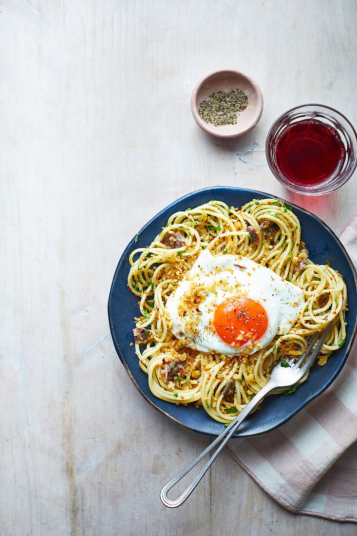 Spaghetti mit geräucherten Sardellen, Chili, Semmelbröseln und Spiegelei