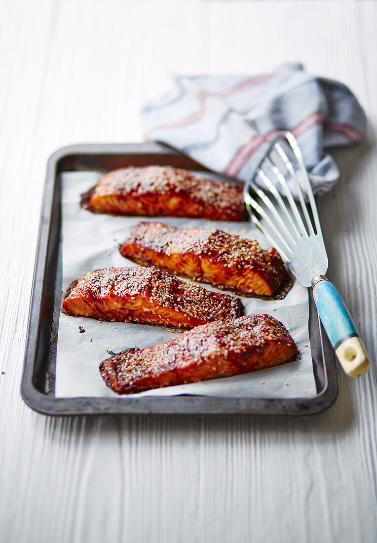Glazed salmon with sesame seeds on an oven tray