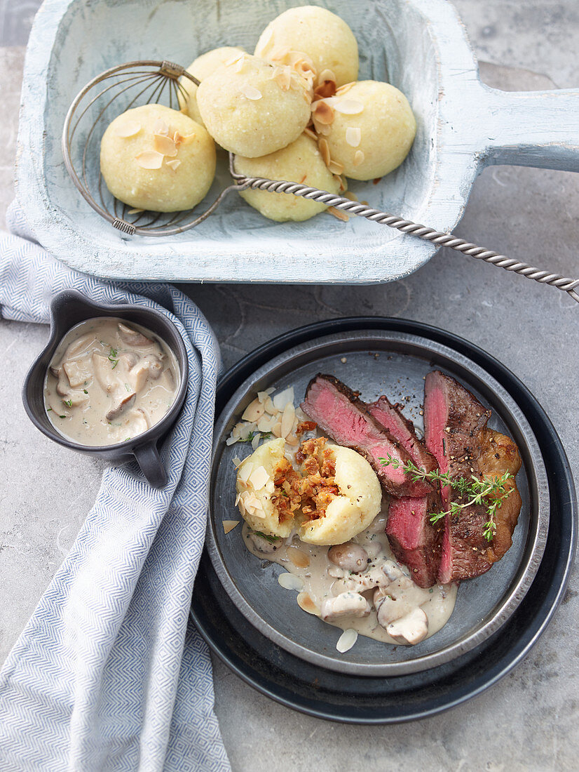 Steaks with almond potato dumplings and creamy mushroom sauce