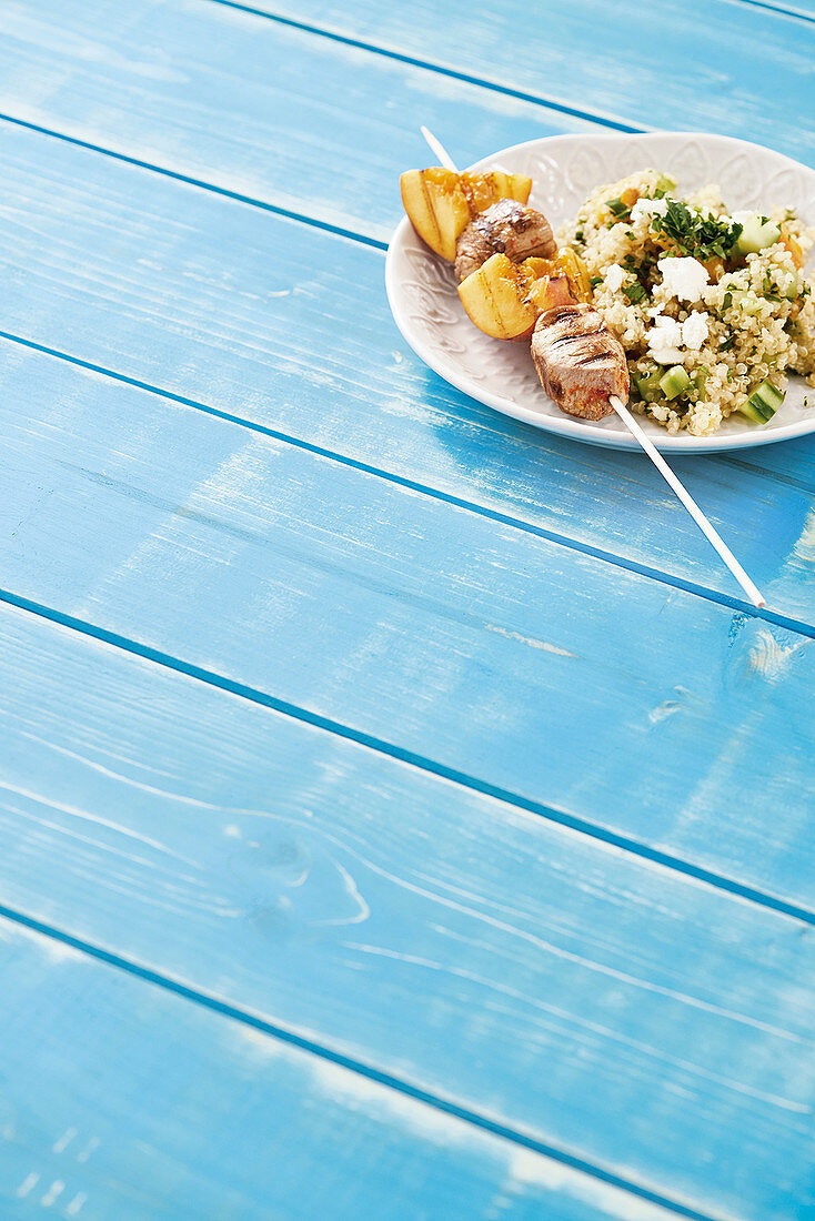Fillet skewers with peach with quinoa salad