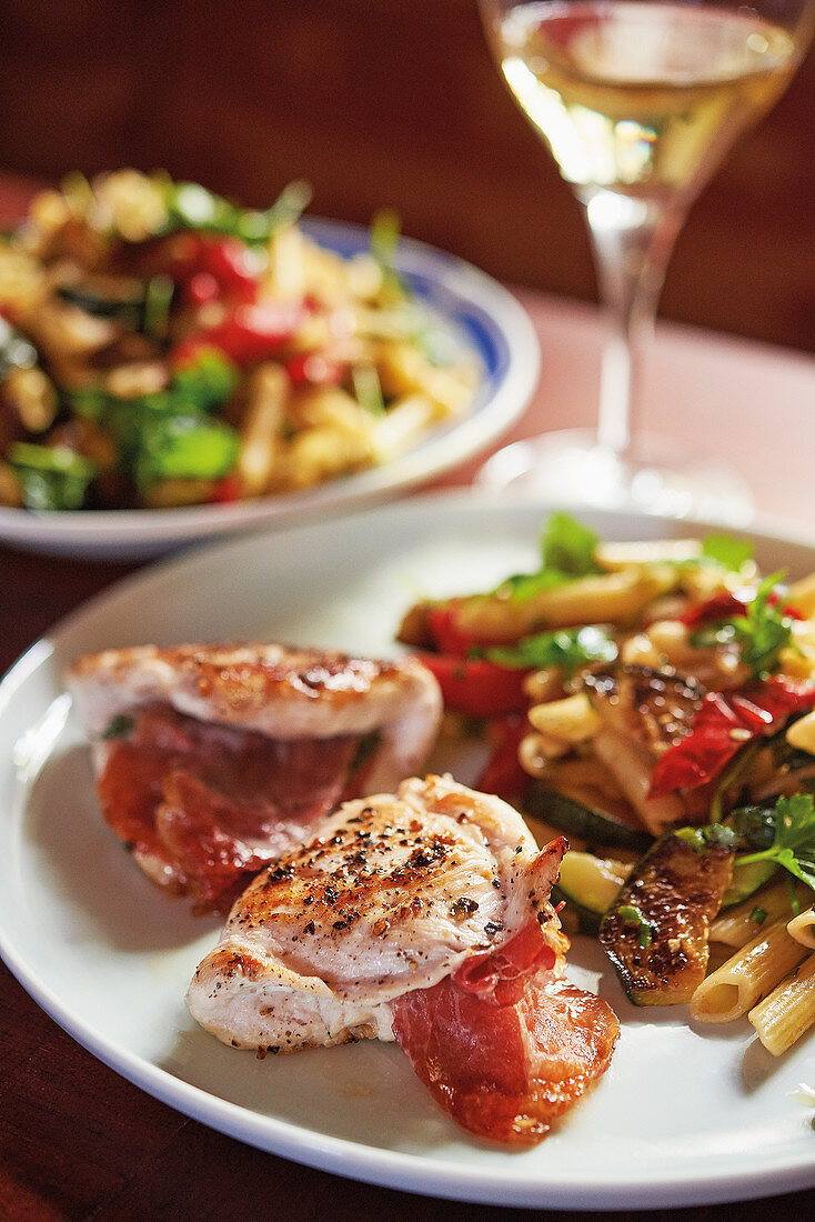 Chicken saltimbocca served with a pasta salad with roasted vegetables