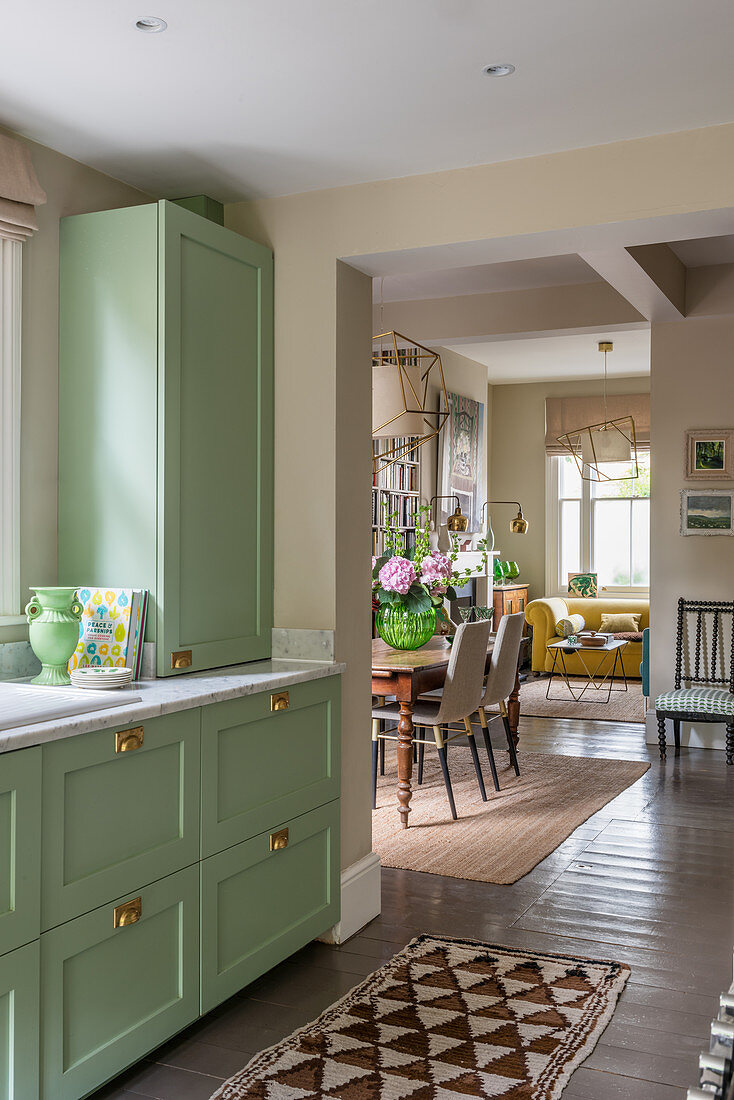 A green sideboard in an open-plan kitchen