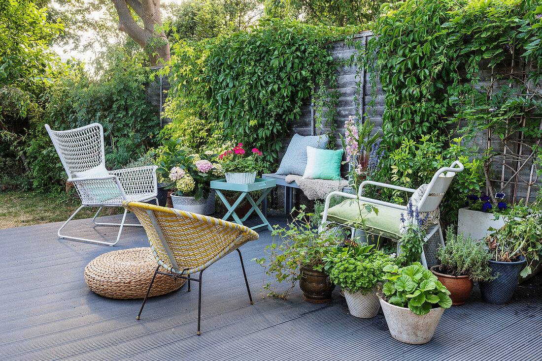 Gartenmöbel und Topfpflanzen auf Holzterrasse