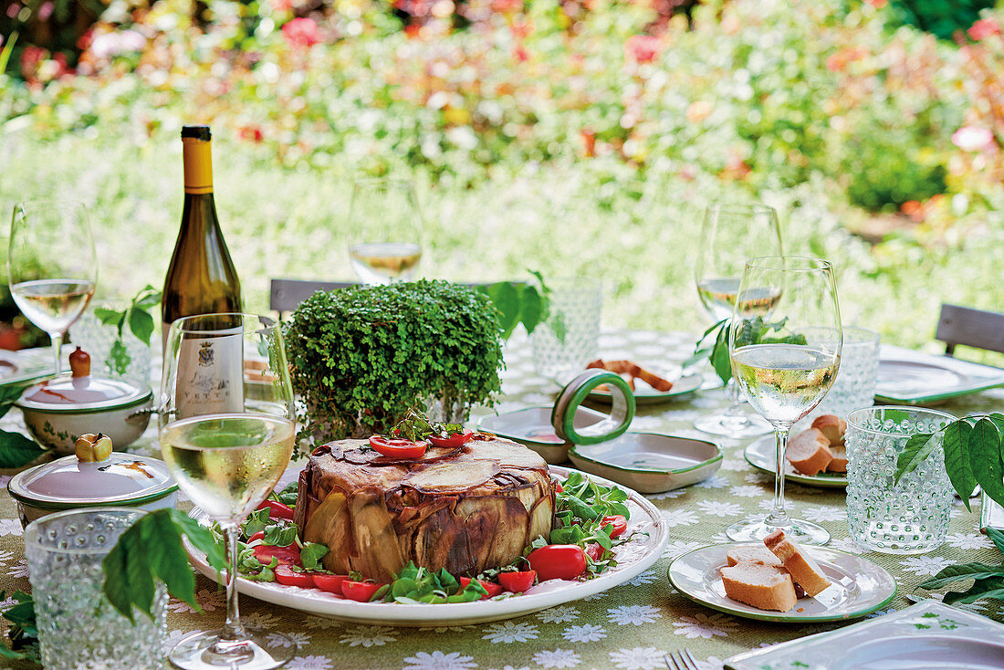 Auberginen-Nudelauflauf auf gedecktem Tisch im sommerlichen Garten