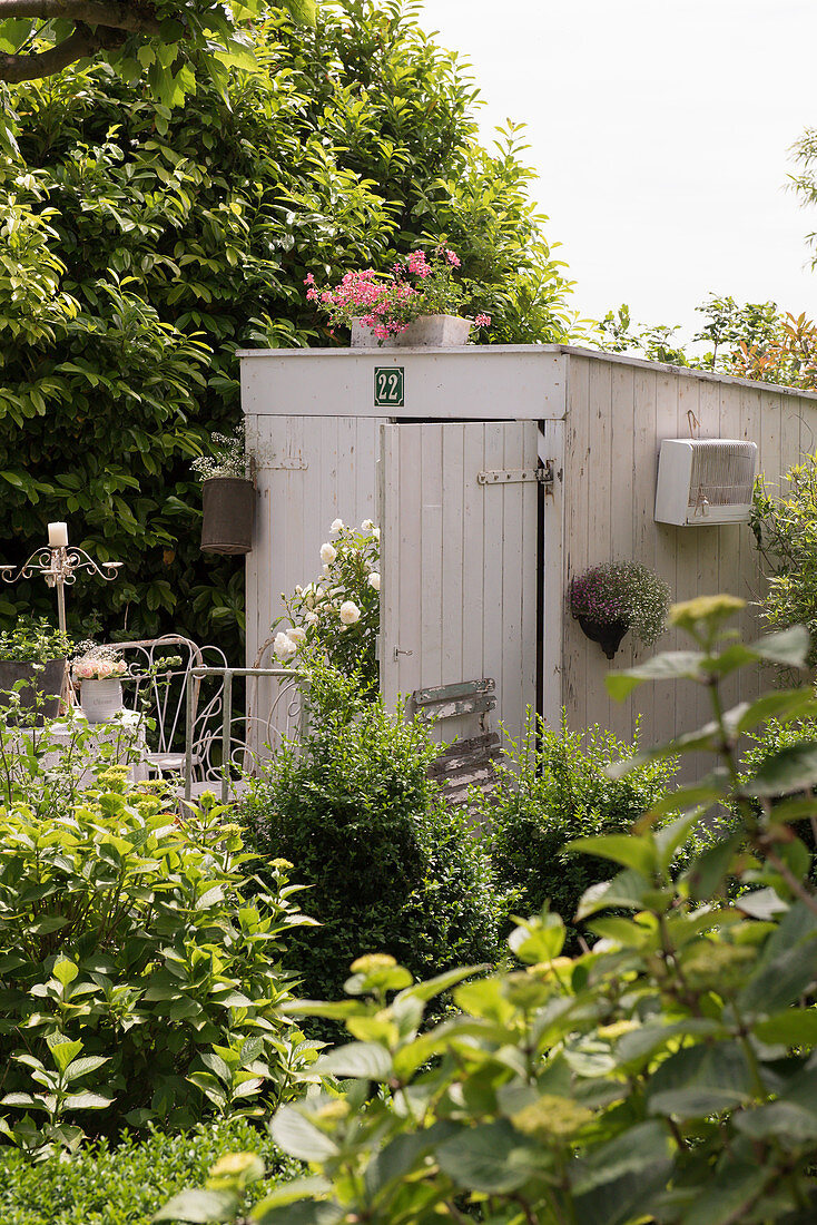 A white wooden summer cottage in a garden