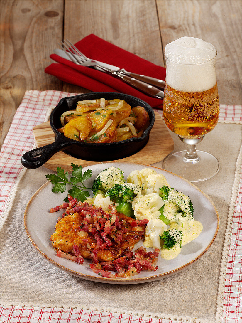 Schnitzel with bacon and fried potatoes