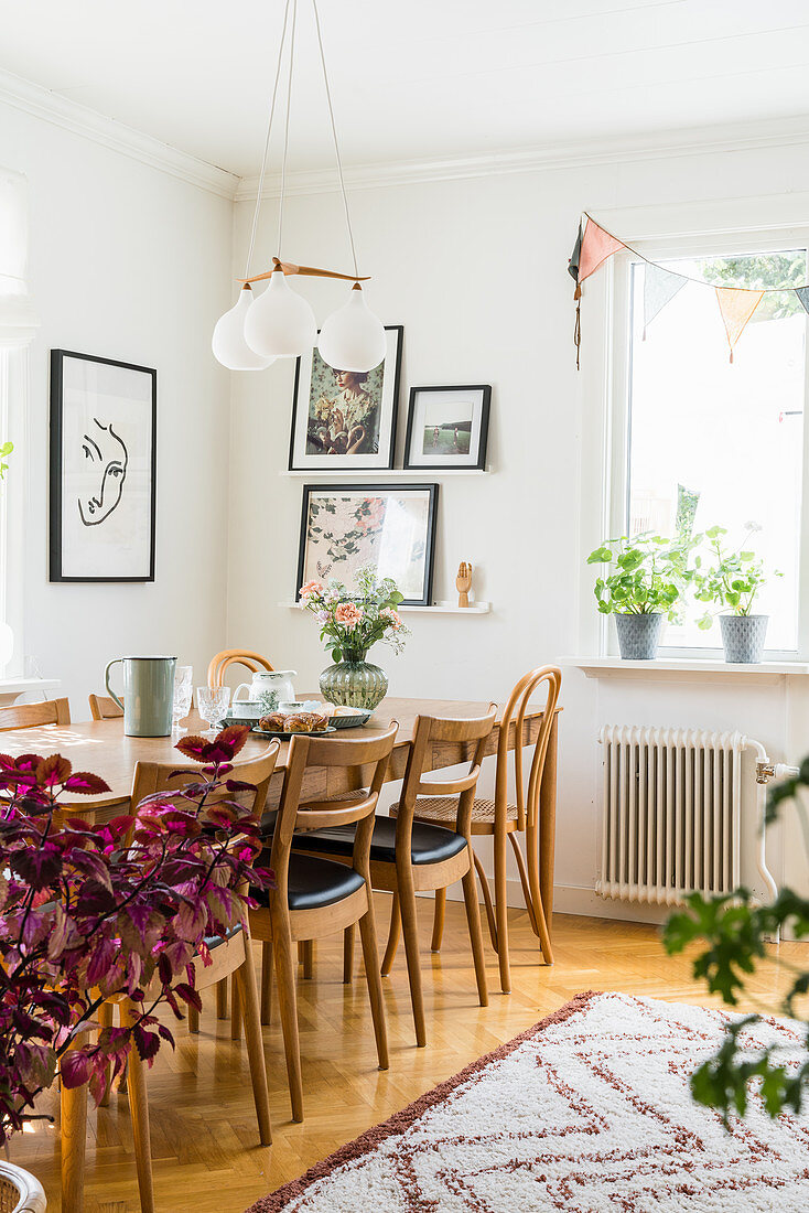 Table and chairs below pendant lamp in dining area