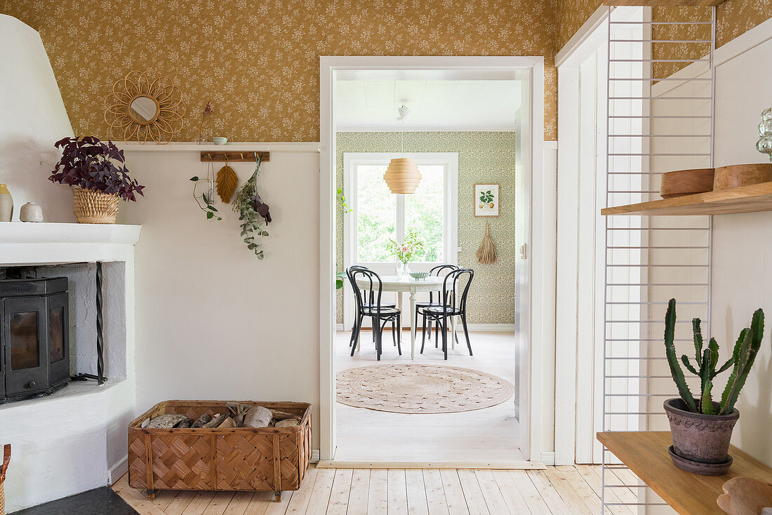 Fireplace in hallway and view of round table and chairs in kitchen