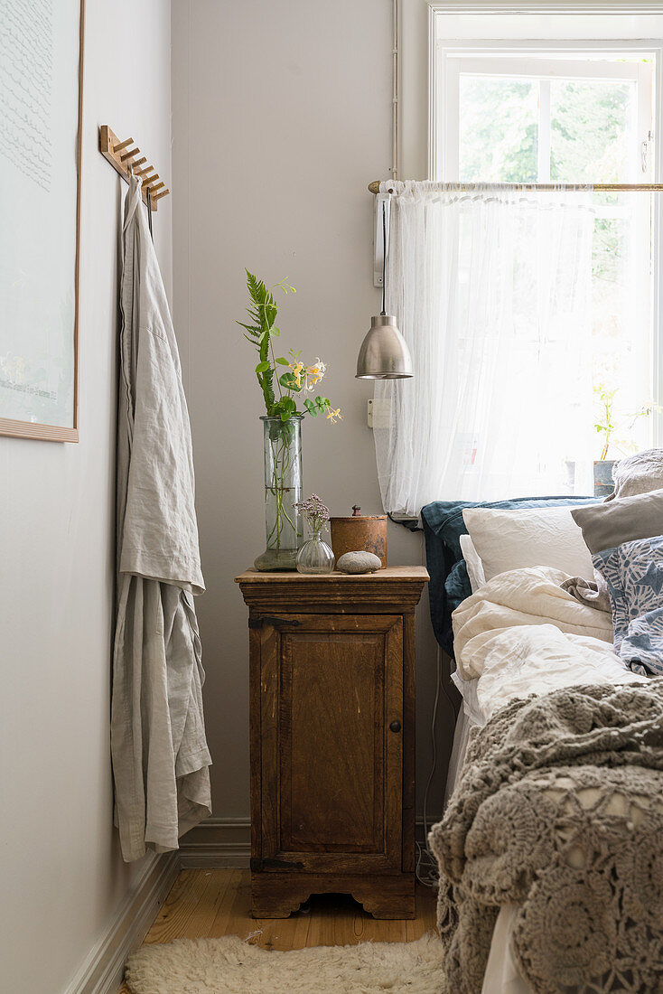 A bedside table next to a bed in a rural bedroom
