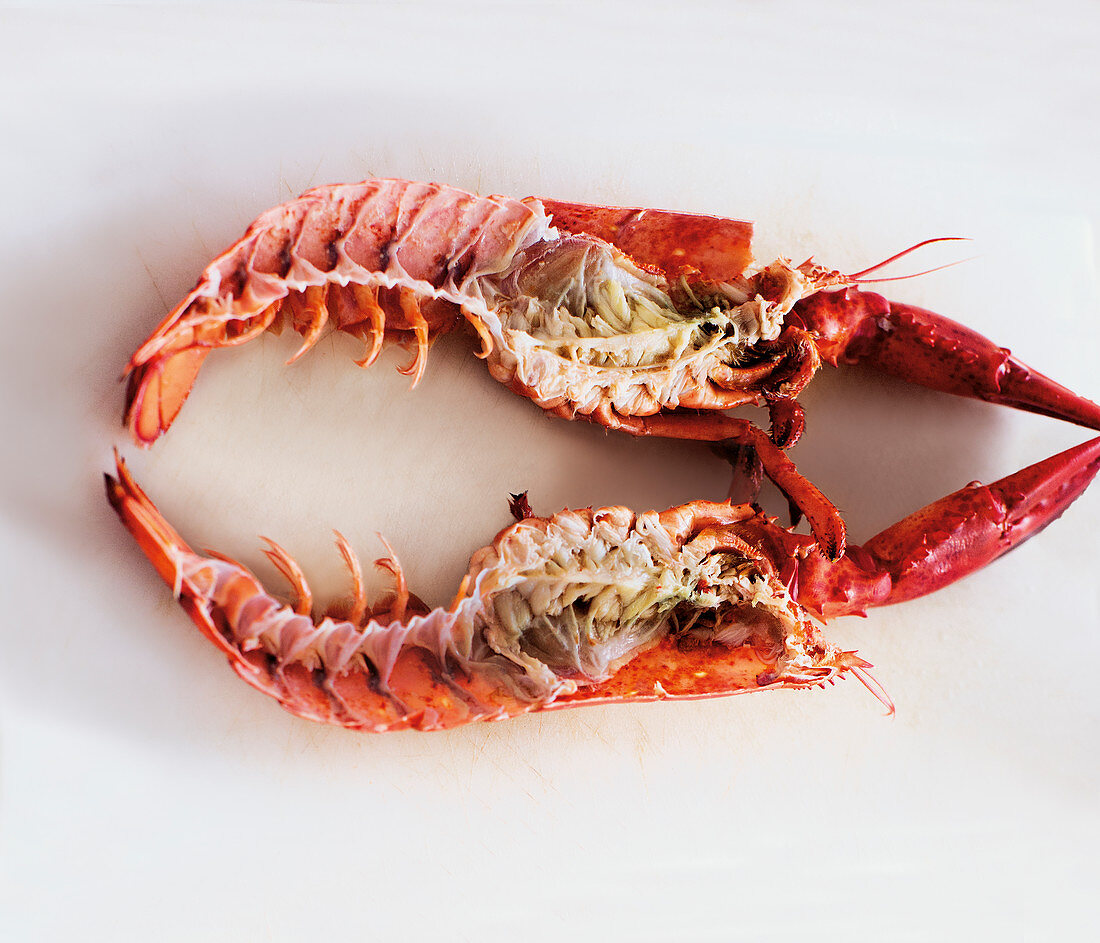 A halved lobster on a white surface