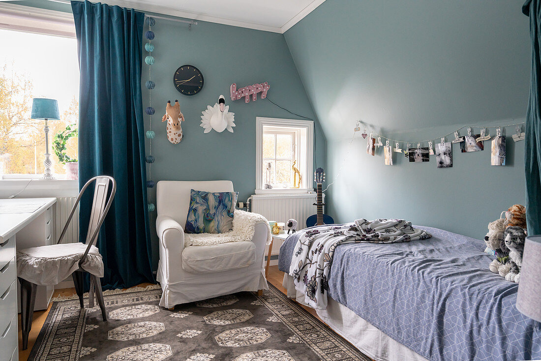 A bed, an armchair and a desk in a boy's room