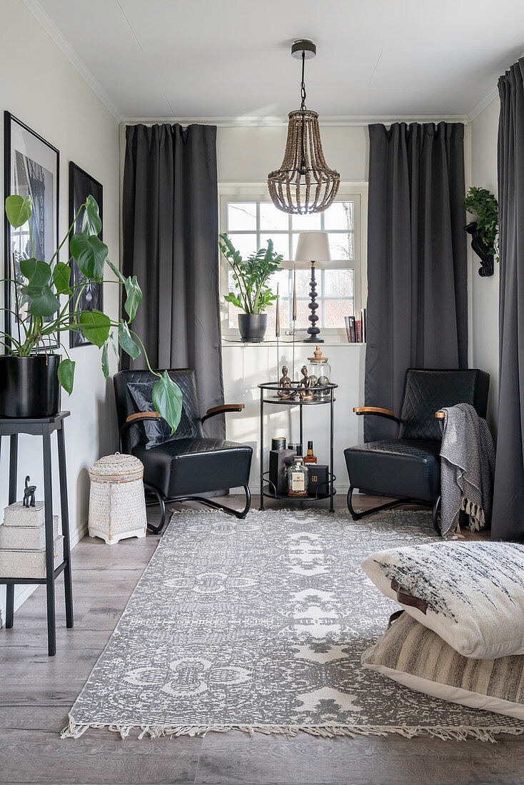 Black leather armchairs and a side table in front of a window