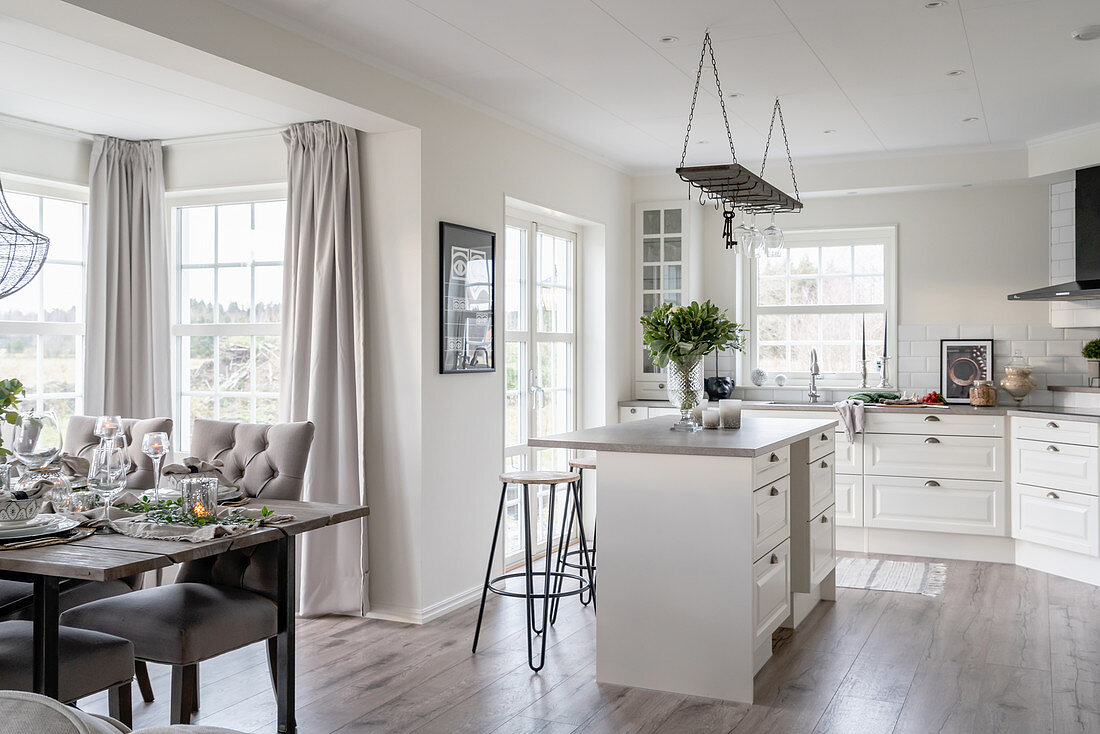 Dining area with upholstered chairs and kitchen island in the open living room