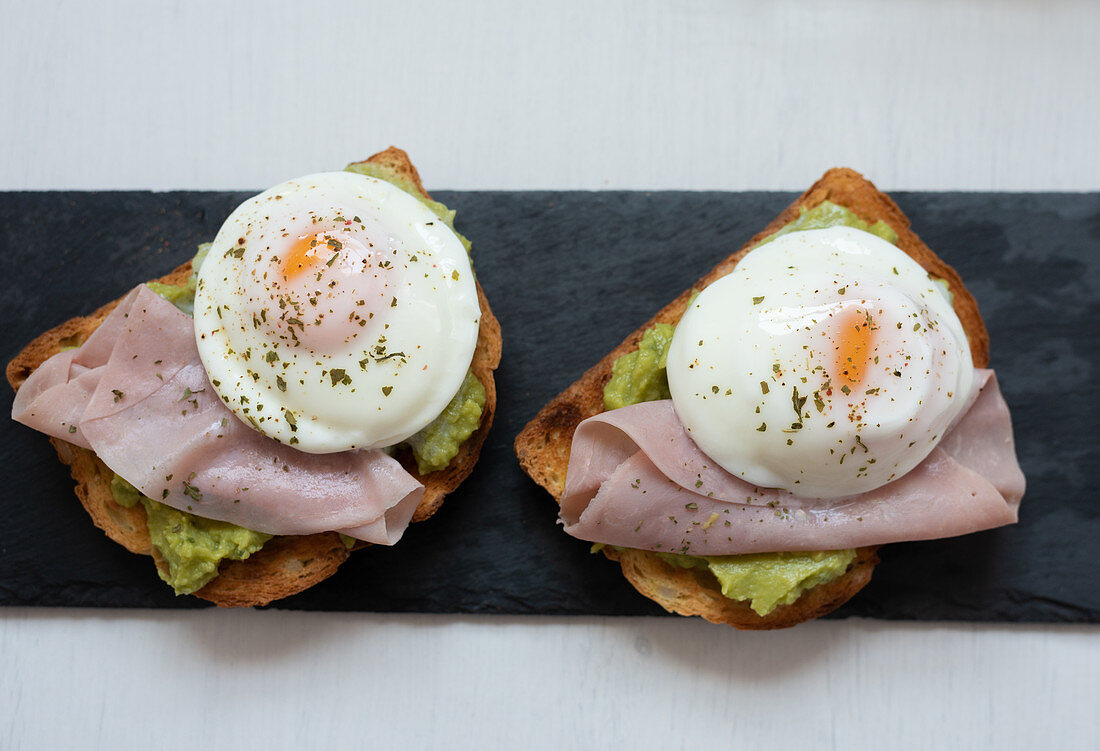 Toasts mit Guacamole, Spiegeleiern und Schinken