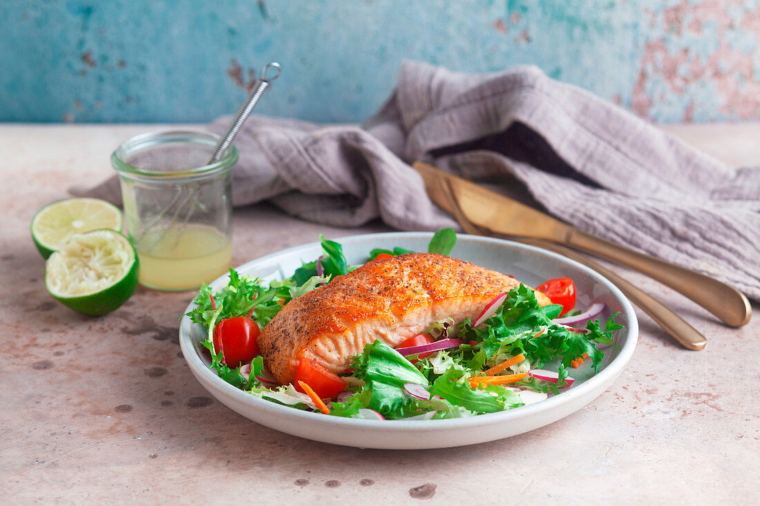 Fried salmon fillet on a mixed leaf salad