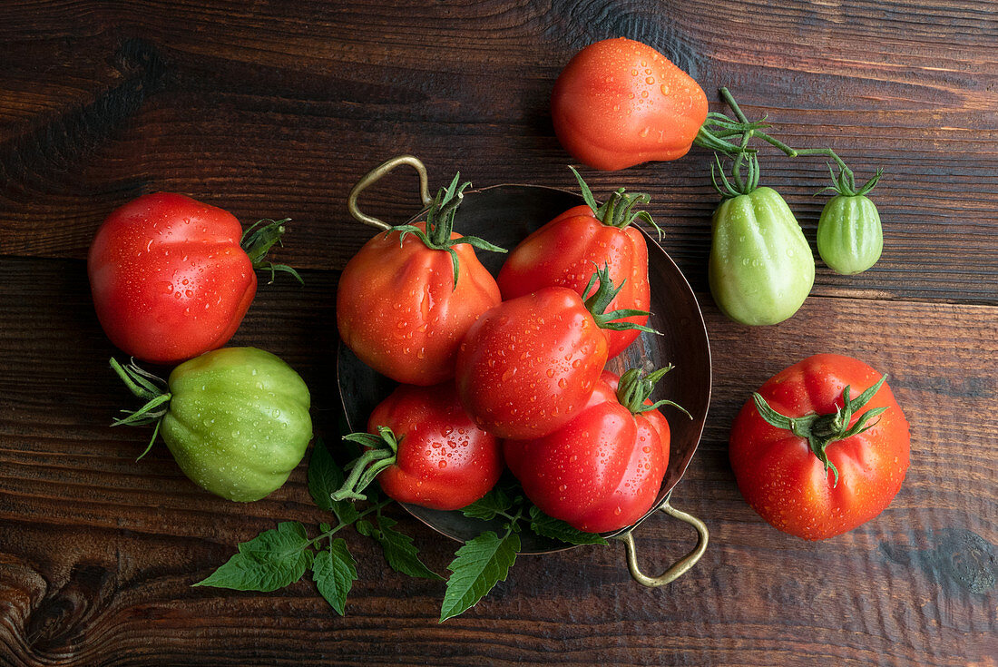 Rote und grüne Tomaten auf Holztisch