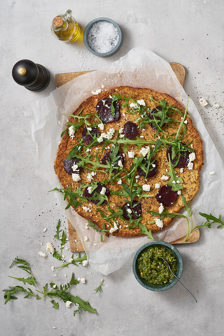 A cauliflower pizza with beetroot, rocket and feta cheese