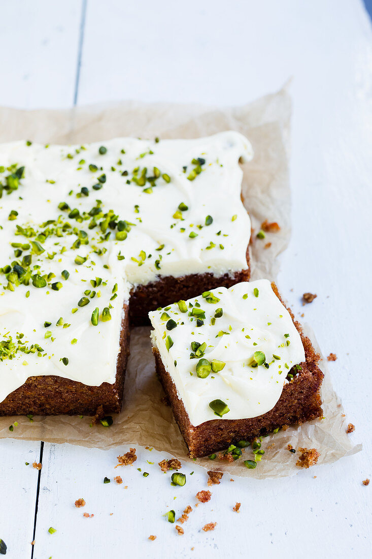 Vegan carrot cake with frosting and pistachio nuts