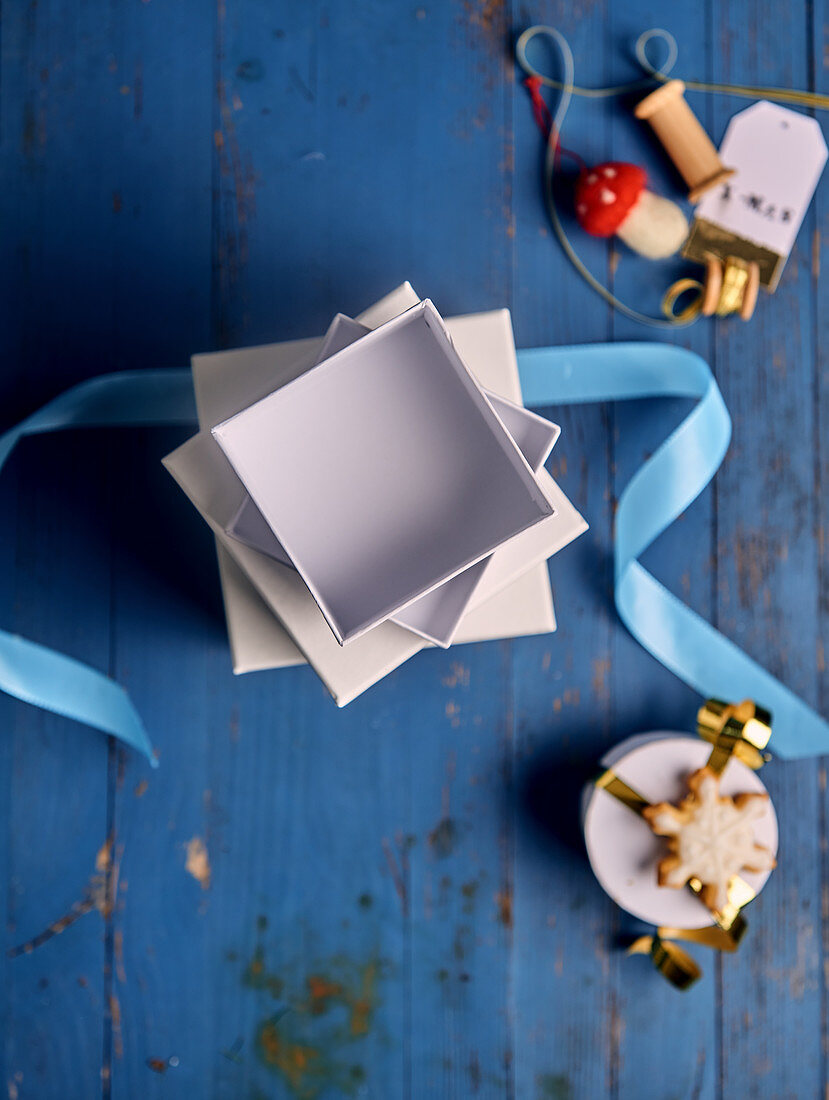 A stack of empty gift boxes with ribbons and Christmas decorations