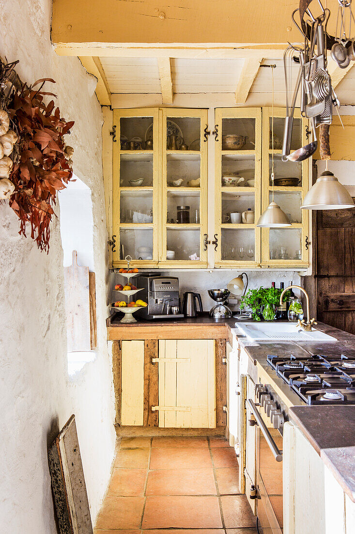 Long counter with gas cooker in country house kitchen with wooden beam ceiling