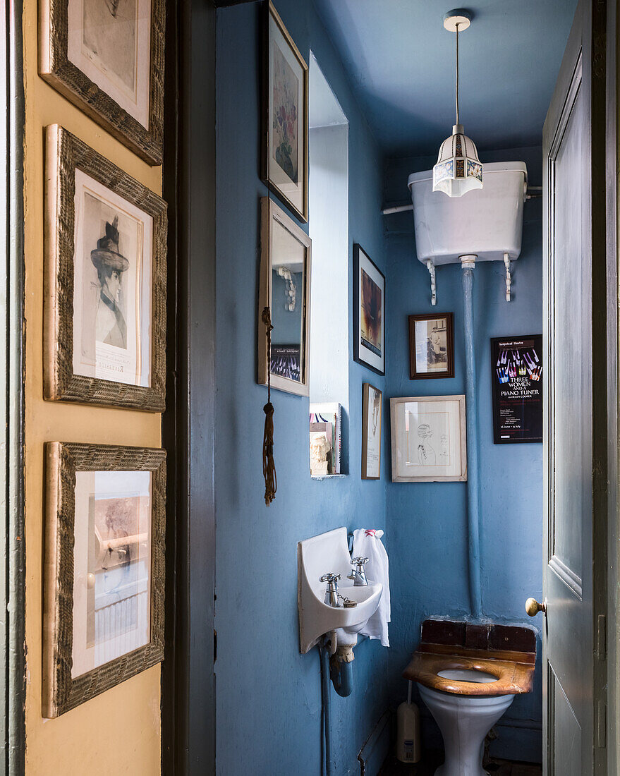 Framed artwork in blue washroom with wall-mounted cistern
