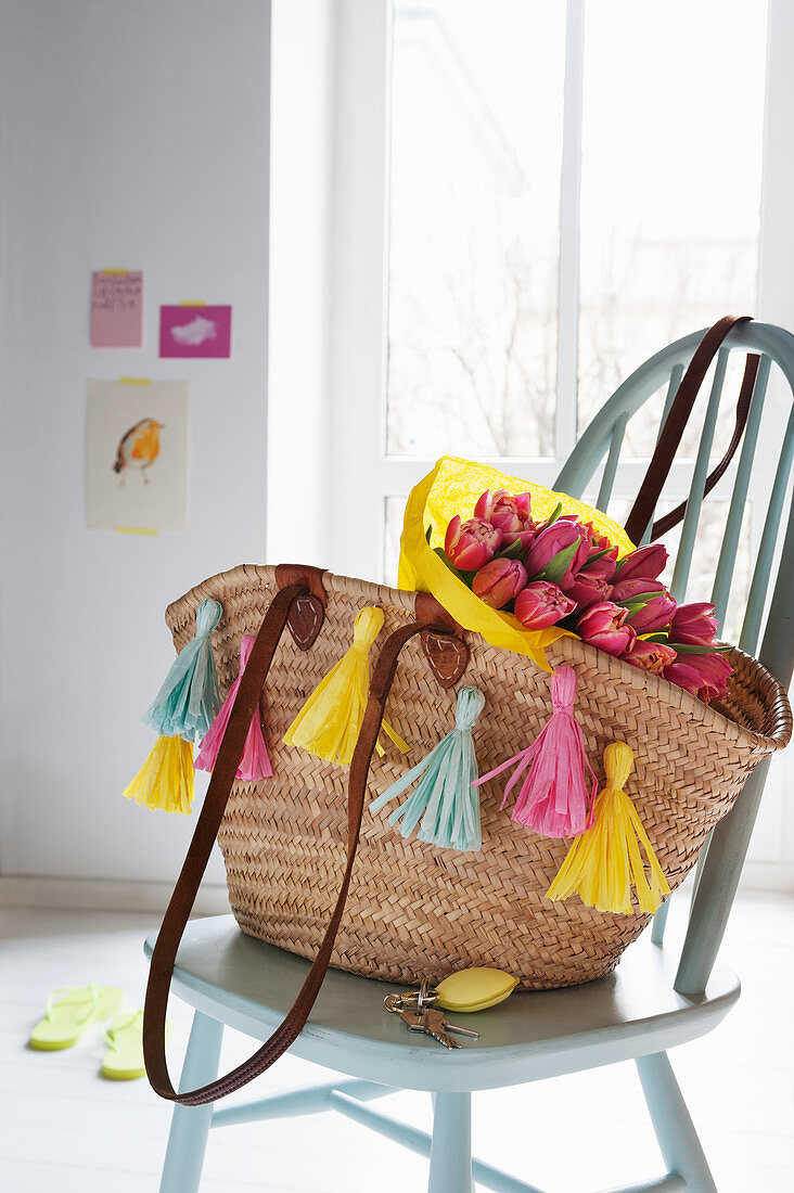 Raffia shopping basket decorated with paper tassels