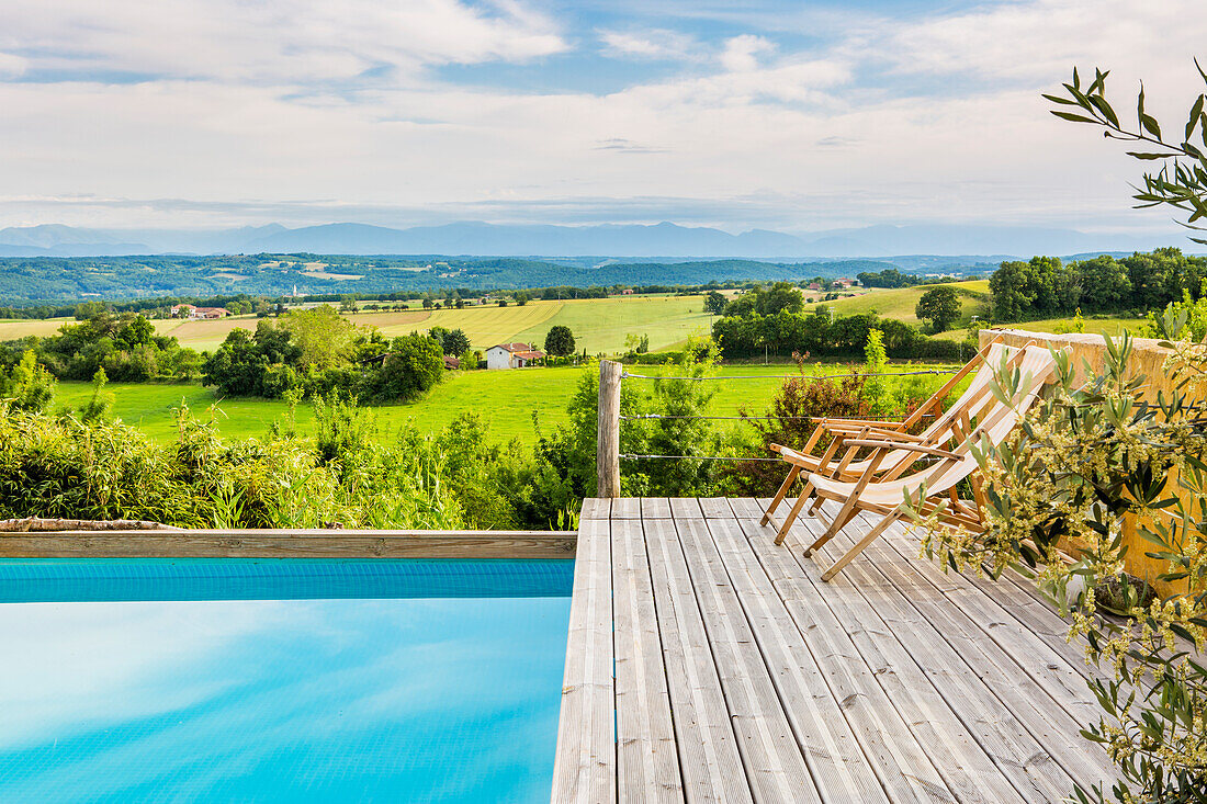 Liegestühle am Pool mit Landschaftsblick