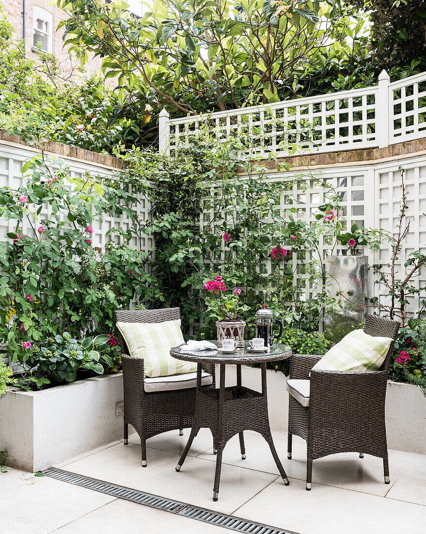 Wicker furniture in courtyard garden of Victorian terrace