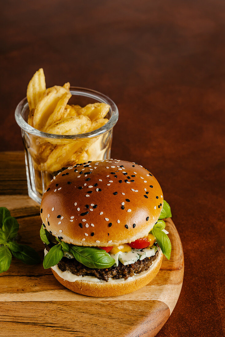 Blue cheese and basil beef burger with mustard barbecue sauce and french fries
