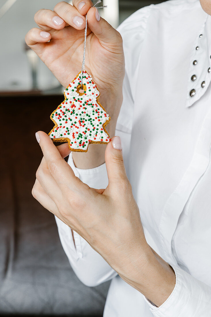 Gingerbread Christmas tree cookie in woman's hands