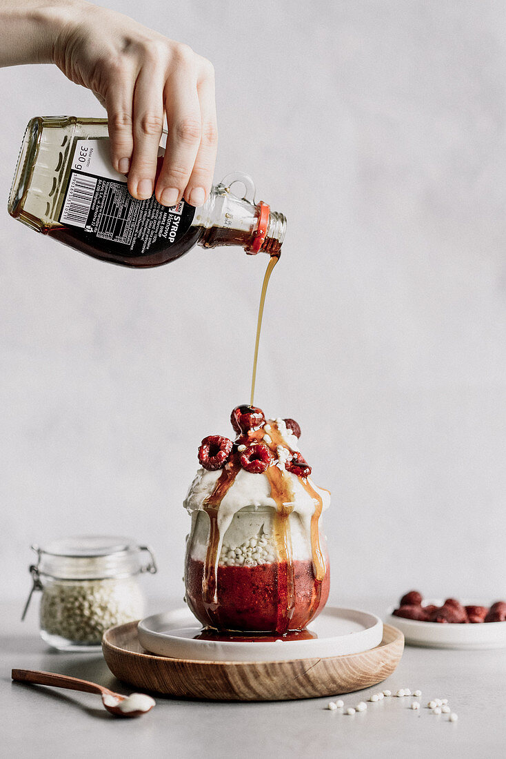 Raspberry dessert with expanded millet banana ice cream topped with maple syrup