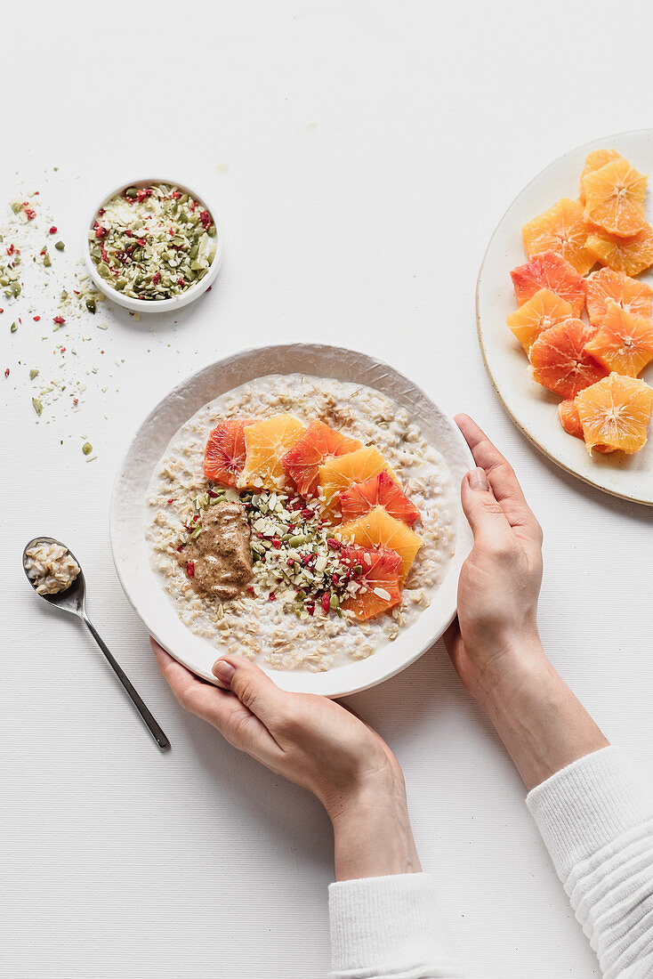 Oatmeal mit Orangenscheiben, Kürbiskernen und Erdnussbutter