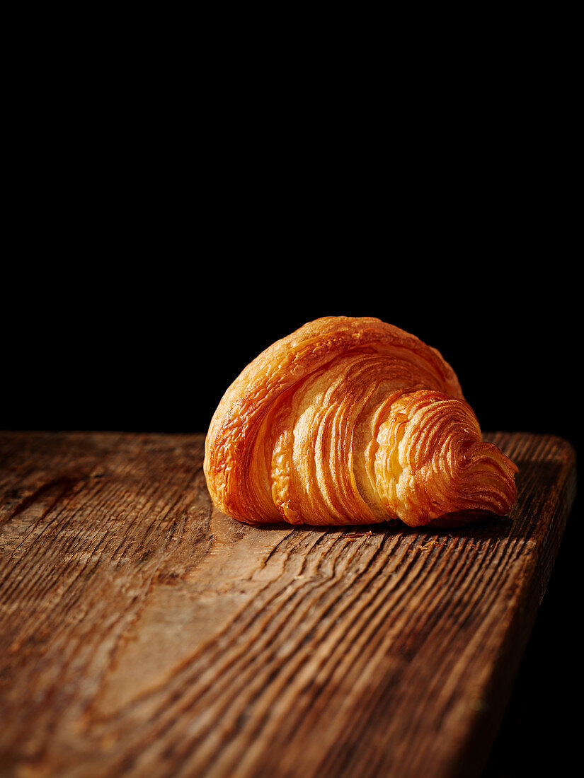 A croissant on a wooden board