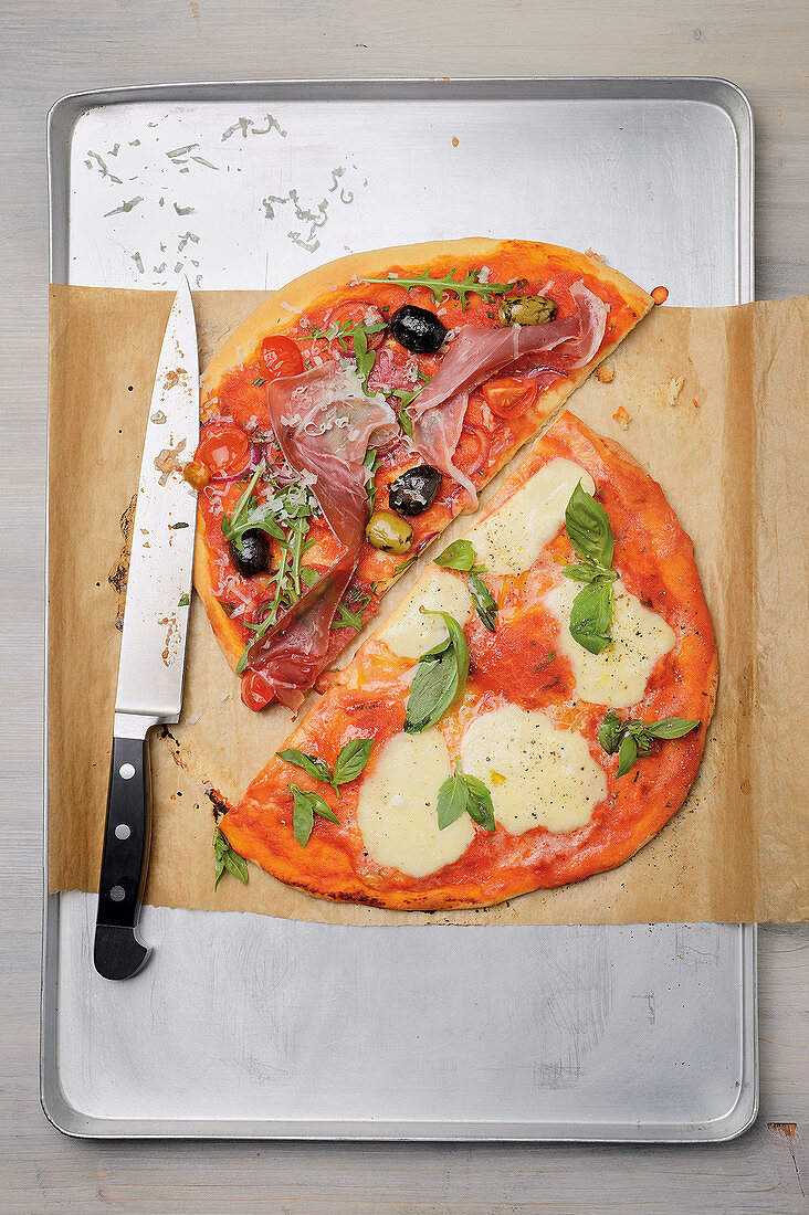 Pizza with Parma ham, olive and rocket, and a mozzarella pizza
