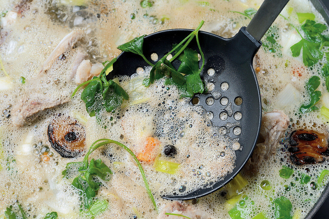 Beef broth with a draining spoon