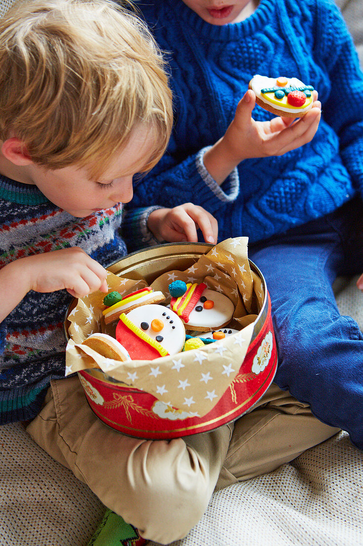 Kinder essen Schneemann-Kekse