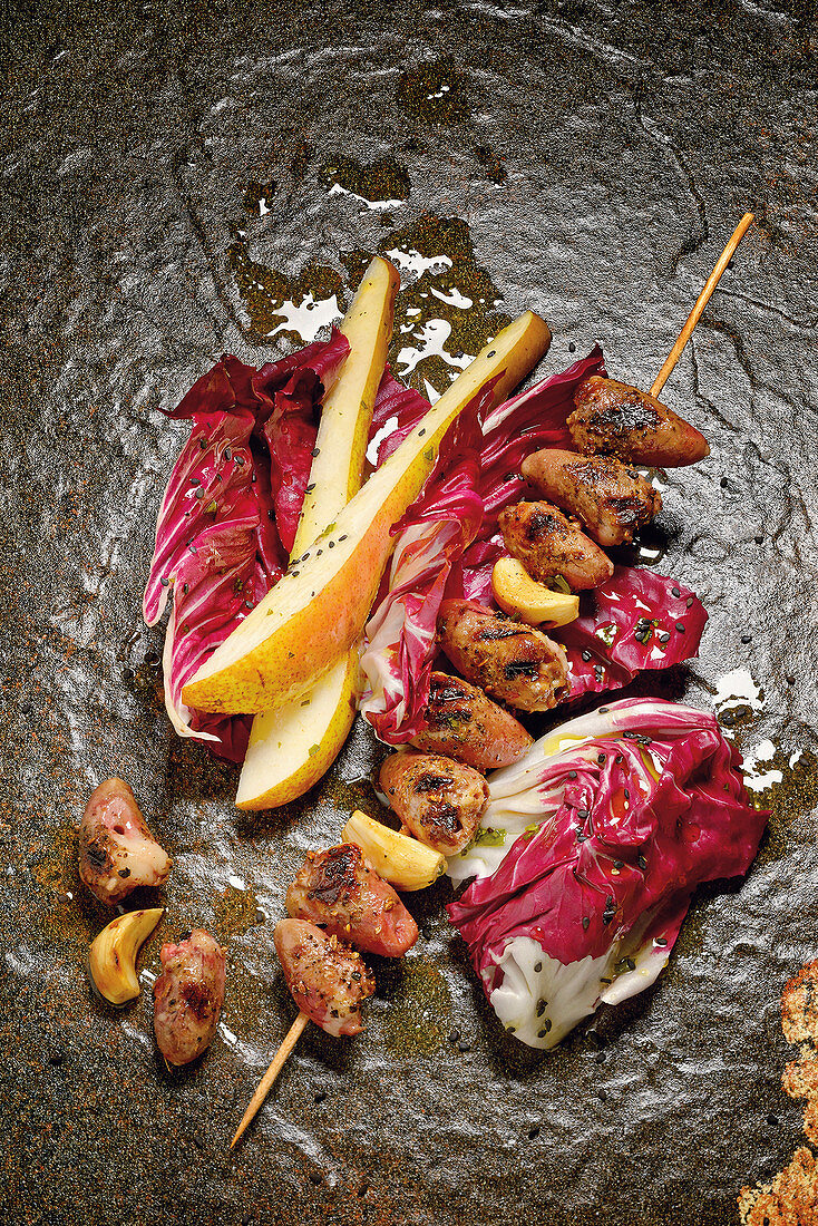 Grilled poultry heart skewers with radicchio and pear salad
