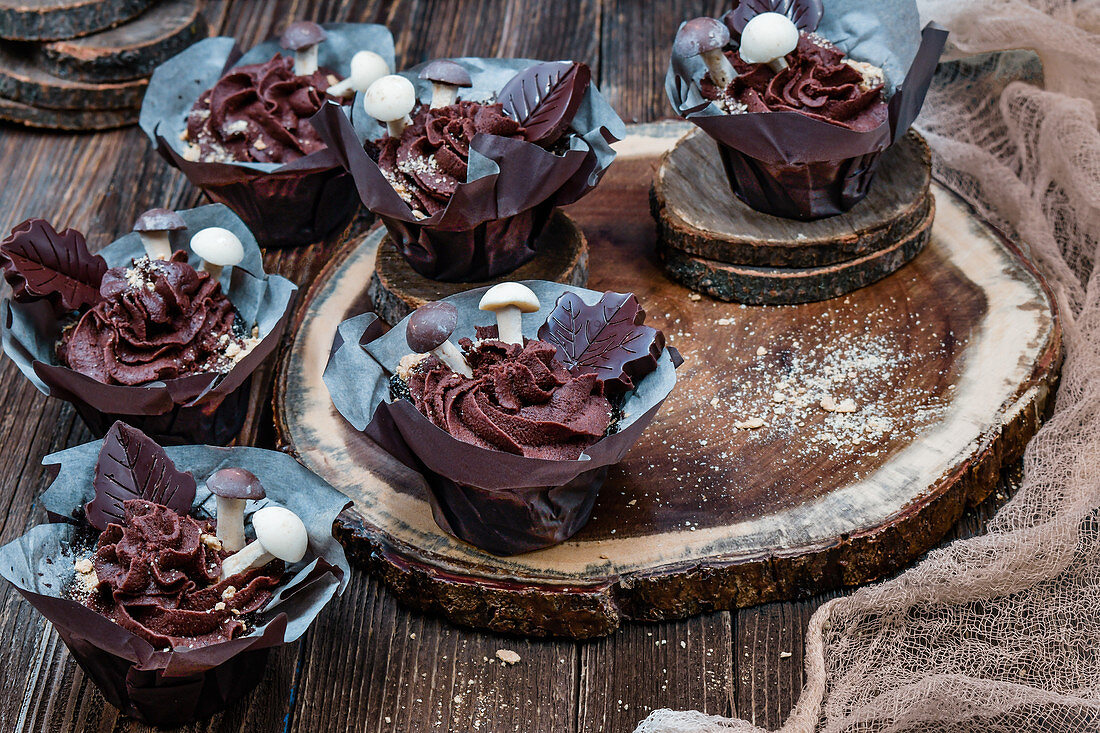 Schokoladen-Cupcakes mit Ganache und Schokoladenpilzen