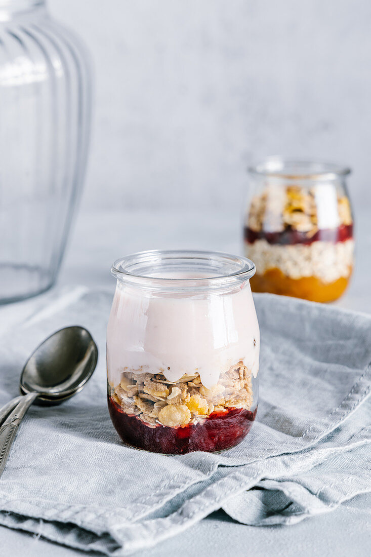 Healthy raspberry parfaits with yogurt in glass jars