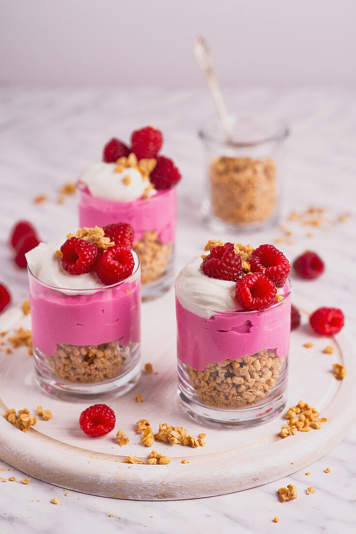 Schichtdessert mit Müsli, Joghurt und Himbeeren