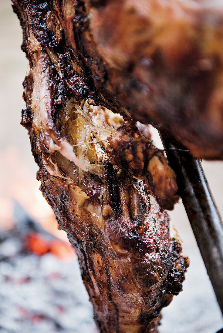 Lammfleisch am Asado-Grillkreuz (Nahaufnahme)