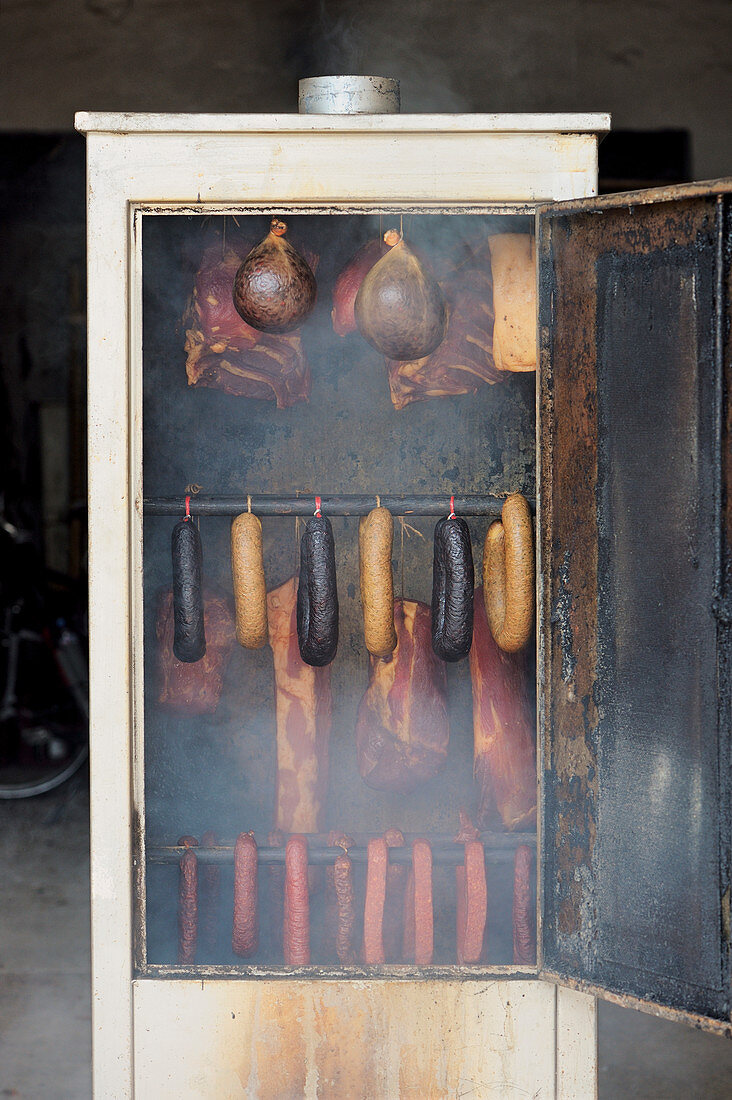 Various types of meat in a smoking oven