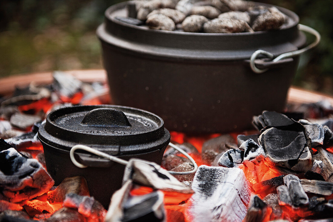 A Dutch oven placed directly on the coals