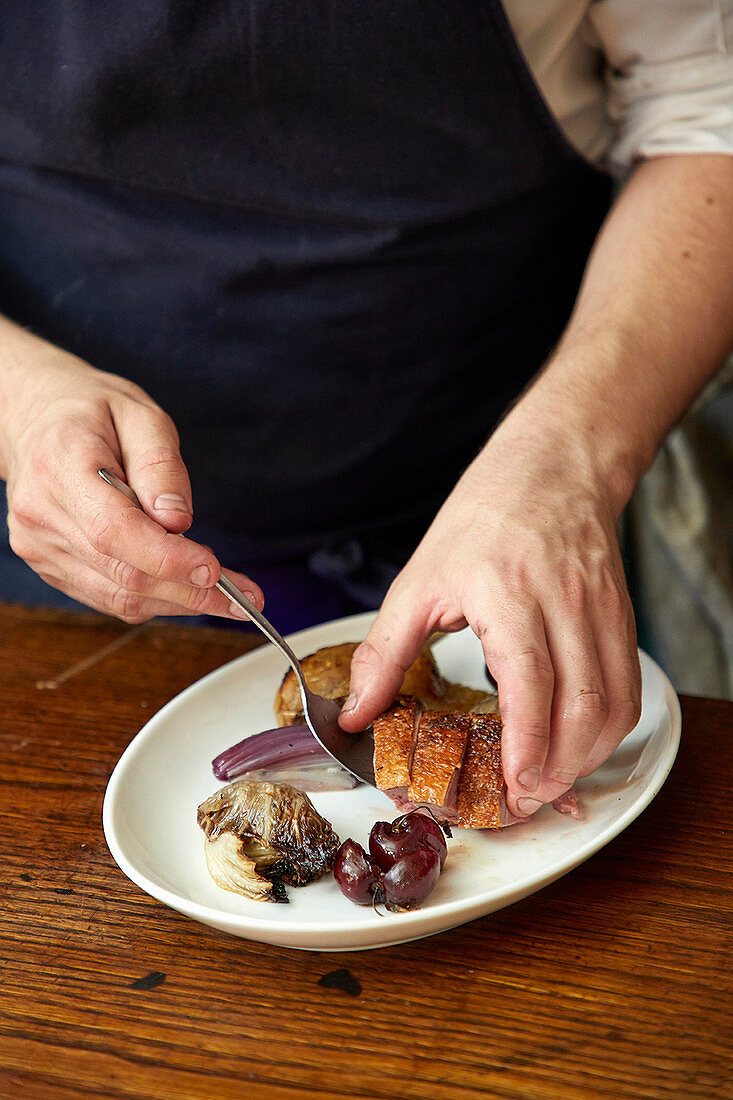 Chef serving duck with radicchio and grapes